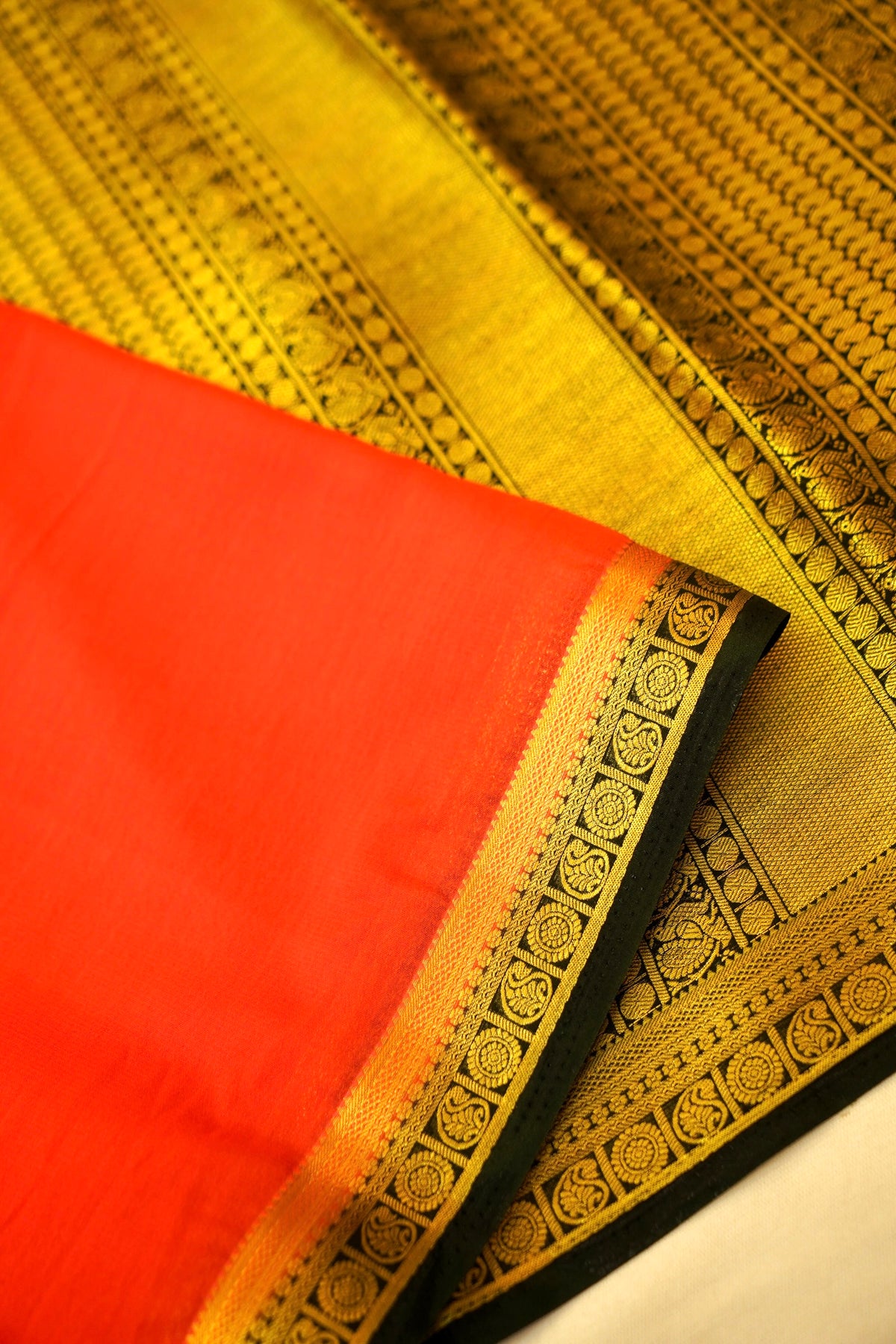 Maithili - Coral Red Mysore Crepe Silk Saree with Black Border